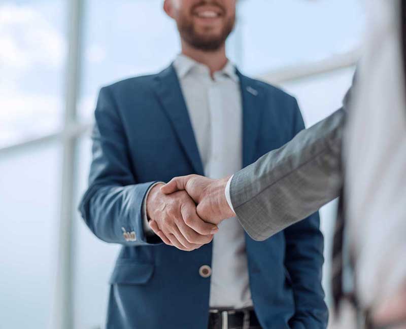 Dos personas cerrando un acuerdo y estrechando manos